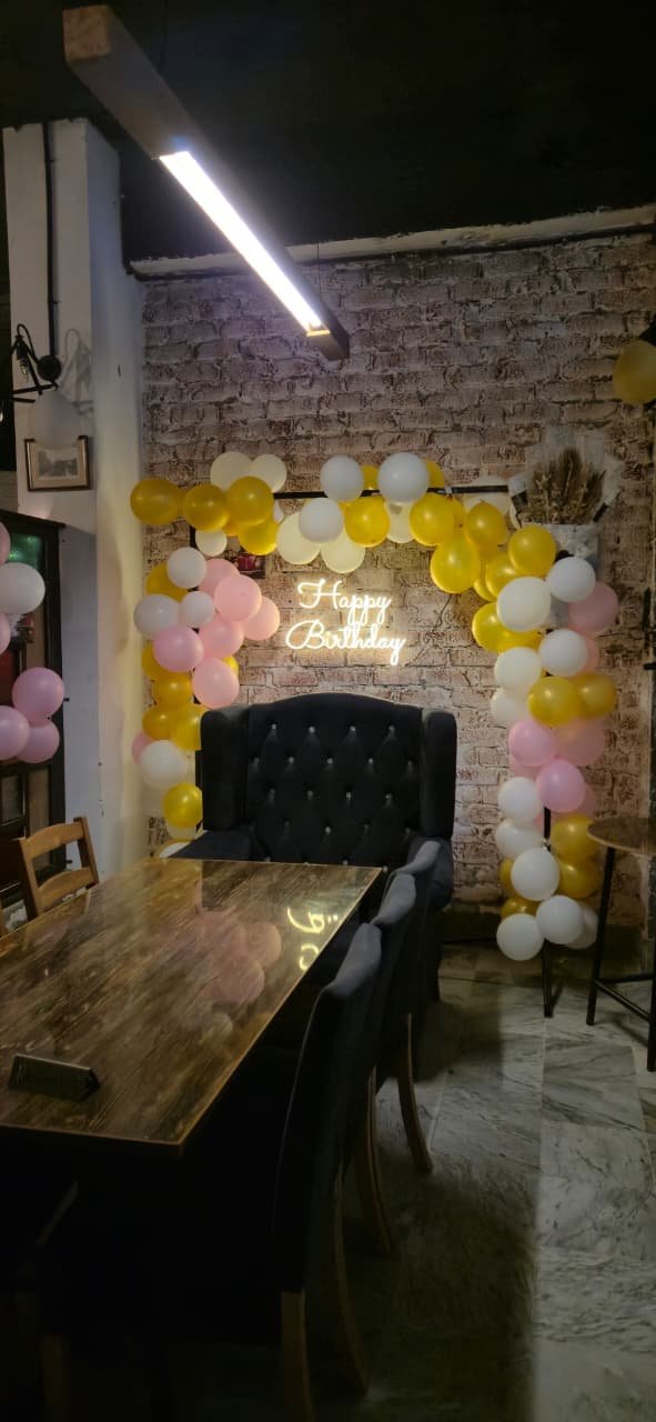 The birthday corner, with a balloon arch and the Happy Birthday sign lit up