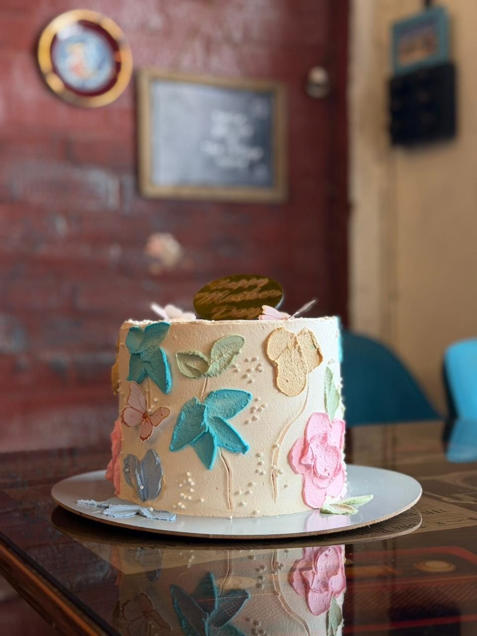 A hand-painted floral cake made in our bakery