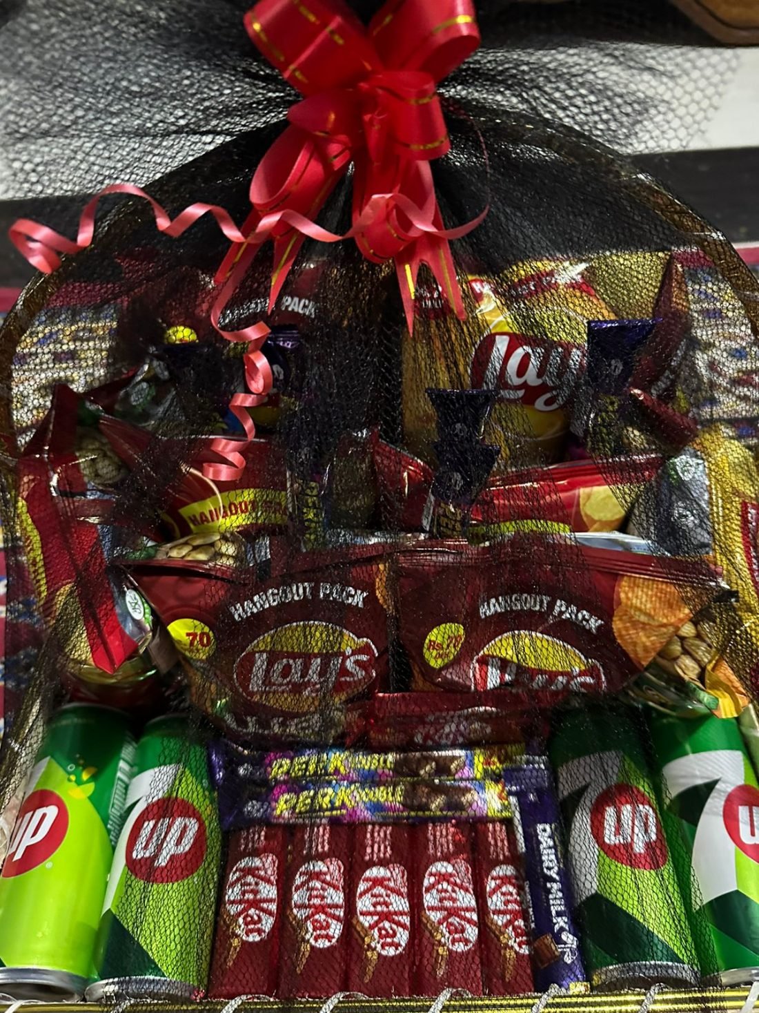 A large snack basket of crisps, chocolate and drinks