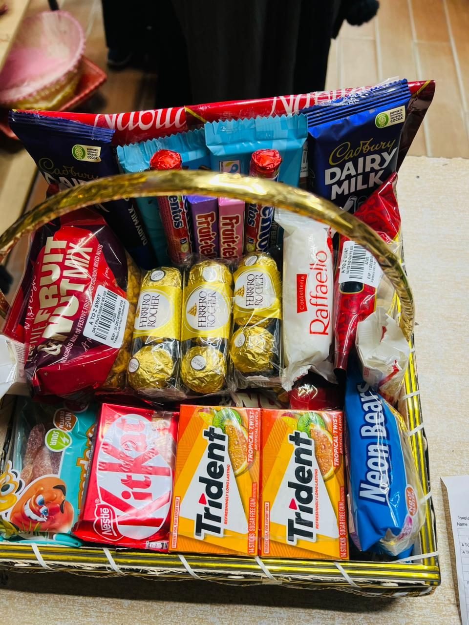A small snack basket of chocolates and crisps